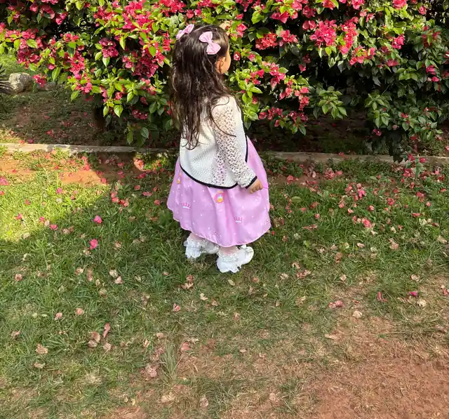 Una niña del hogar mirando las flores del jardín