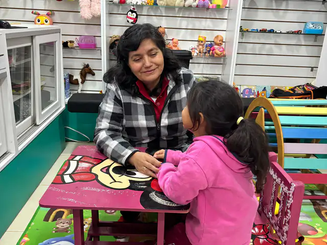 Zunilda ayudando a una niña con la tarea